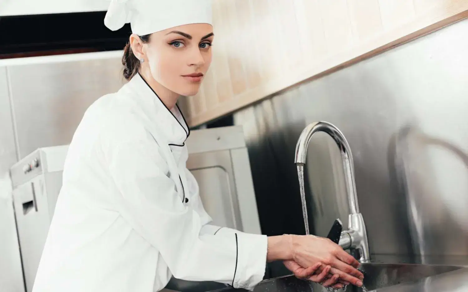 Hygiena v pohostinství s kuchařkou myjící si ruce