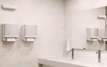 Papierhandtuchspender von CWS an der Wand eines Waschraums