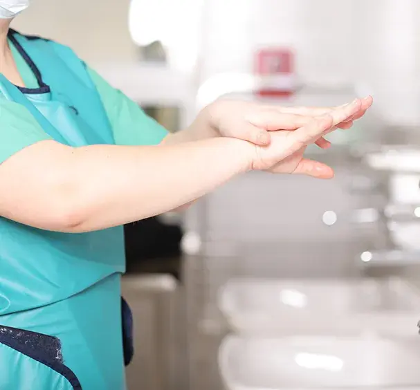 Krankenschwester reibt sich die Hände mit Desinfektionsmittel ein