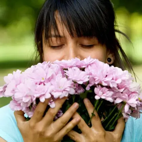 Persoon ruikt aan bloemen